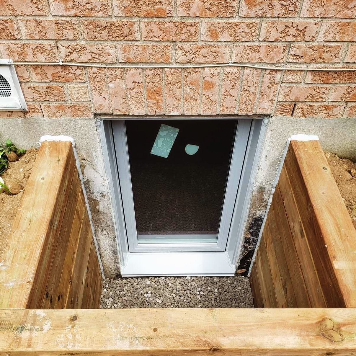exterior of an Egress window with a pressure treated window well