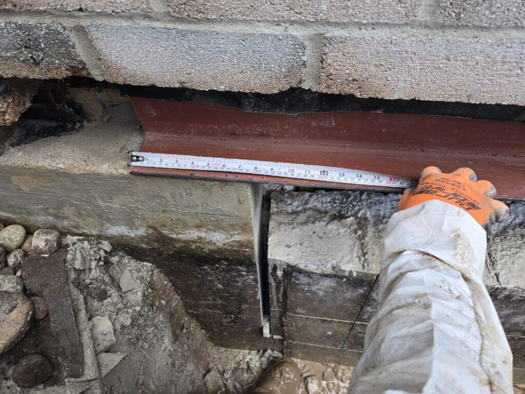 Measuring the steel lintel over a widened basement window opening, Burlington